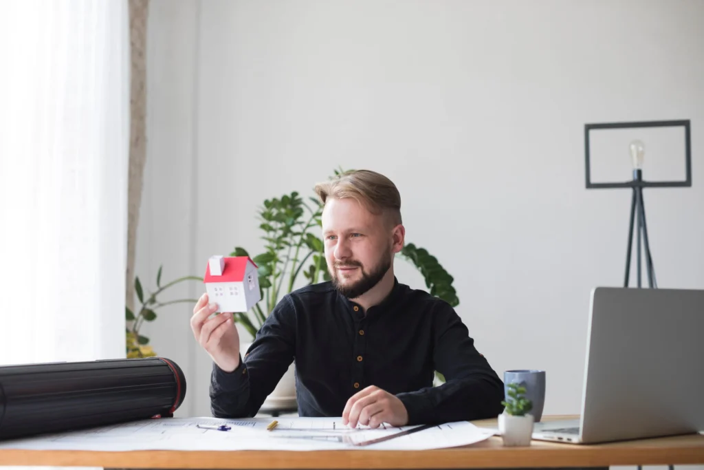 A man looks at a house model.