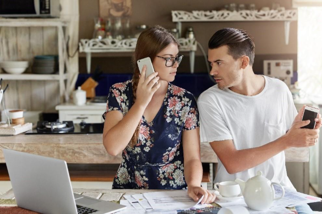 a-couple managing their budget together in the kitchen.